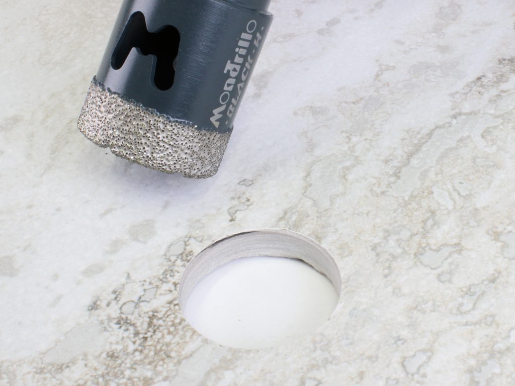 foro in una piastrella di porcellanato eseguito con fresa diamantata